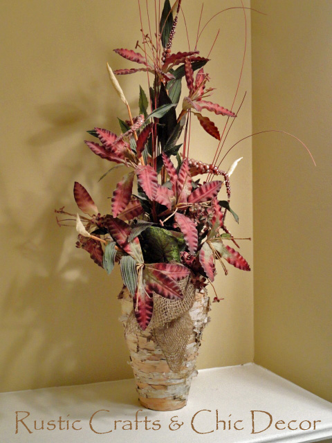 Rustic birch vase with a burlap garland tie and burgundy flowers